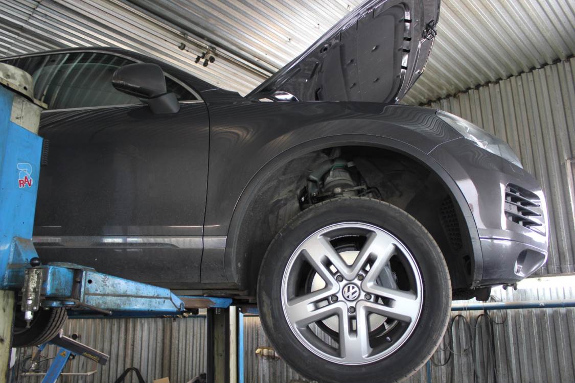 Туарег с открытым капотом на подъемнике